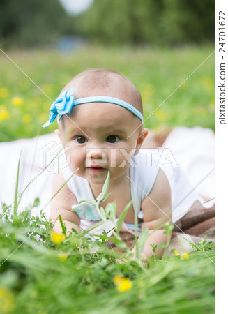 Baby girl crawling on the grass. Selective focus Baby girl crawling on the grass. Selective focus 24701672