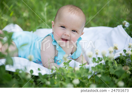 Baby girl crawling on the grass. Selective focus Baby girl crawling on the grass. Selective focus 24701673