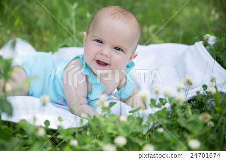 Baby girl crawling on the grass. Selective focus Baby girl crawling on the grass. Selective focus 24701674