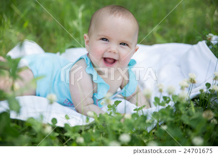 Baby girl crawling on the grass. Selective focus Baby girl crawling on the grass. Selective focus 24701675