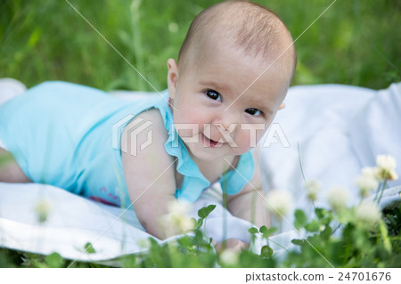 Baby girl crawling on the grass. Selective focus Baby girl crawling on the grass. Selective focus 24701676
