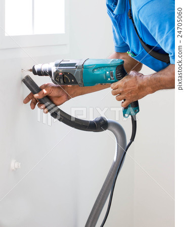 Asian Man Drill On White Wall And Cleaning Dust Asian Man Drill On White Wall And Cleaning Dust 24705060