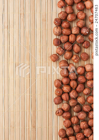 Peeled filbert lying on a bamboo mat 24707463