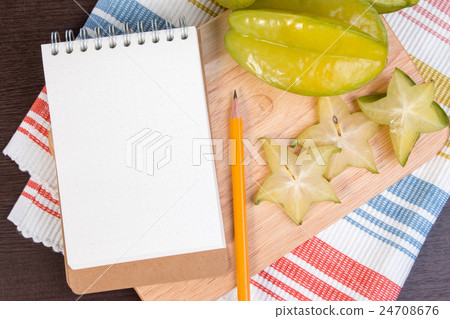 Star apple and notebook on wooden block. Star apple and notebook on wooden block. 24708676