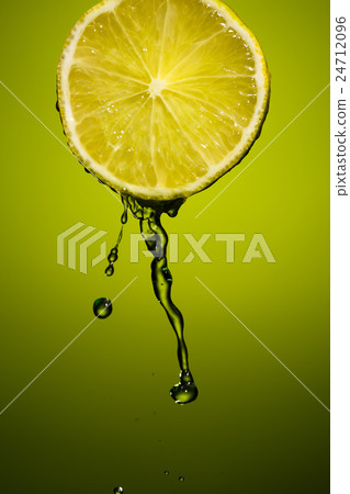 Lime slice and splash of juice isolated on green Lime slice and splash of juice isolated on green 24712096