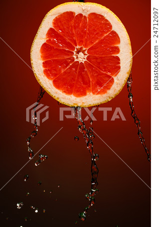 Fresh water drops on grapefruit at red background Fresh water drops on grapefruit at red background 24712097