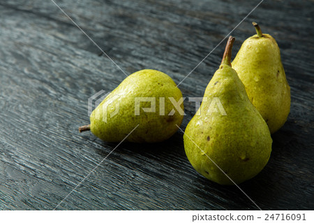 Three green pear on a black background Three green pear on a black background 24716091