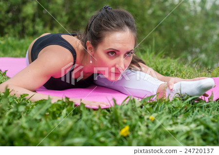 Fit woman stretching, exercising on mat in nature. Fit woman stretching, exercising on mat in nature. 24720137