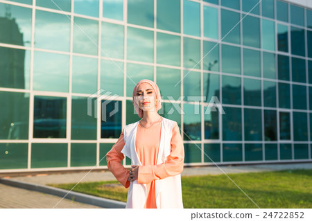 Young woman wearing hijab head scarf in city. 24722852