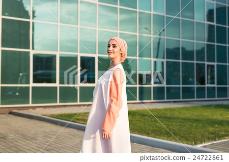 Young woman wearing hijab head scarf in city. Young woman wearing hijab head scarf in city. 24722861