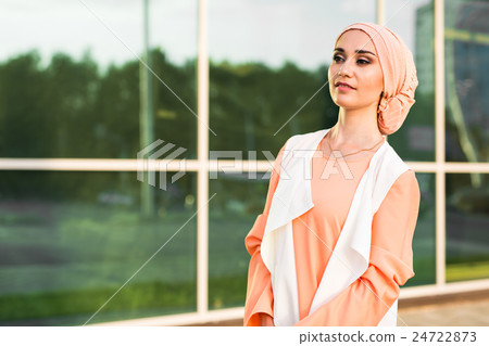 Young woman wearing hijab head scarf in city. 24722873