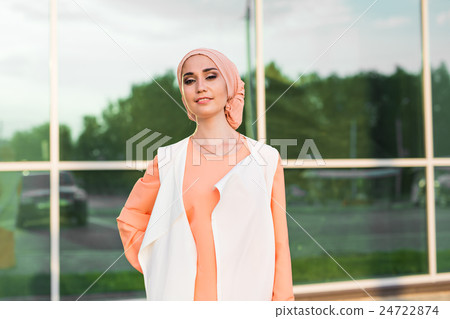 Young woman wearing hijab head scarf in city. 24722874