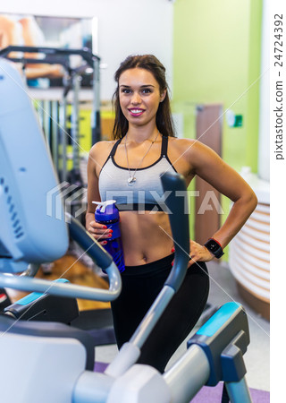 Fit woman doing exercise on a elliptical trainer. 24724392