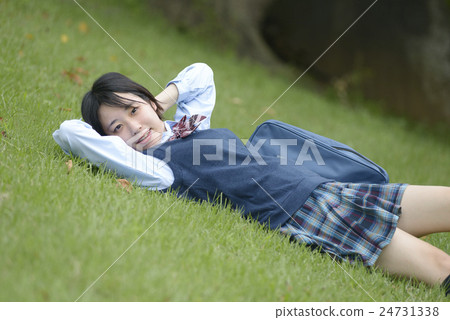 Girls high school student lying on lawn Girls high school student lying on lawn 24731338