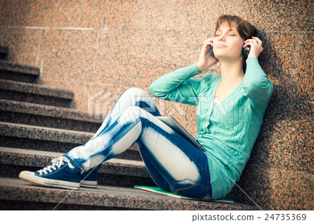 Beautiful young woman student with headphones 24735369
