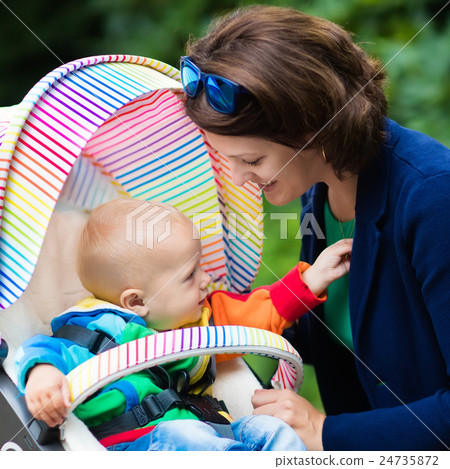 Mom and baby in a stroller Mom and baby in a stroller 24735872