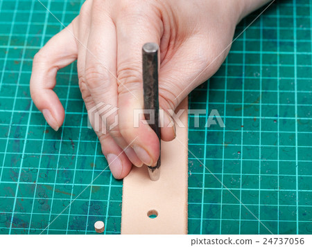 punching hole in new belt with steel punch 24737056