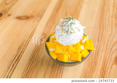 Korean style fresh mango shaved ice on wood table . 24745733