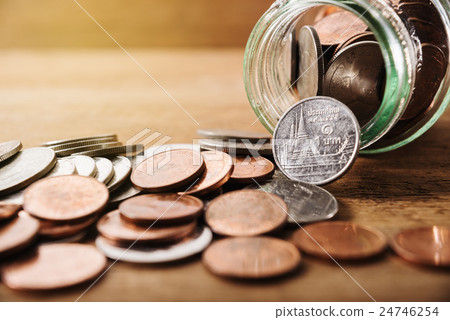 Coins spilling out of a glass bottle Coins spilling out of a glass bottle 24746254