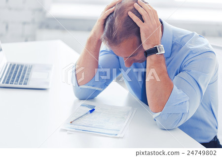stressed businessman with papers at work stressed businessman with papers at work 24749802
