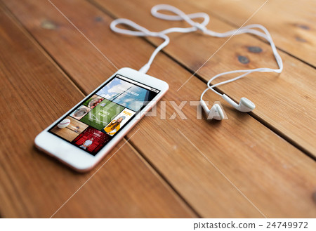 close up of smartphone and earphones on wood close up of smartphone and earphones on wood 24749972
