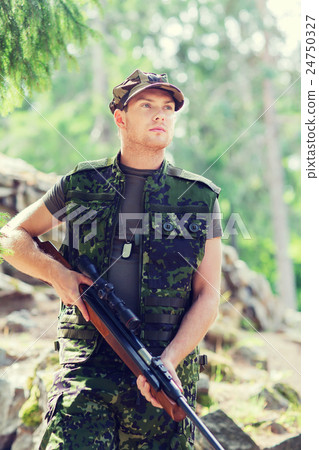 young soldier or hunter with gun in forest 24750327