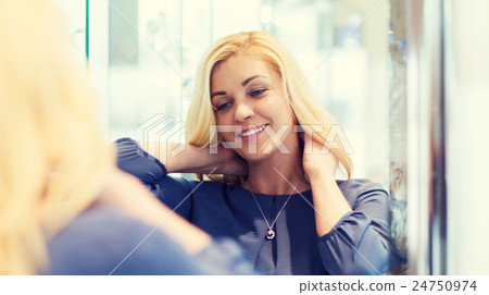 Stock Photo: happy woman choosing pendant at jewelry store