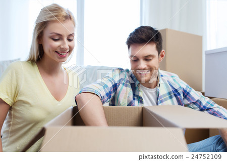 smiling couple with big boxes moving to new home smiling couple with big boxes moving to new home 24752109