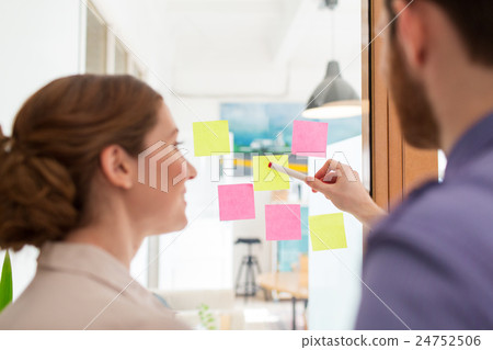 creative team with stickers on glass at office 24752506