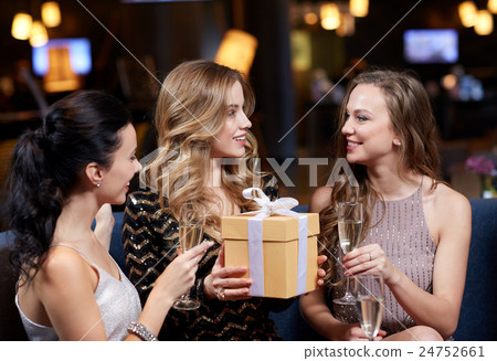 happy women with champagne and gift at night club 24752661
