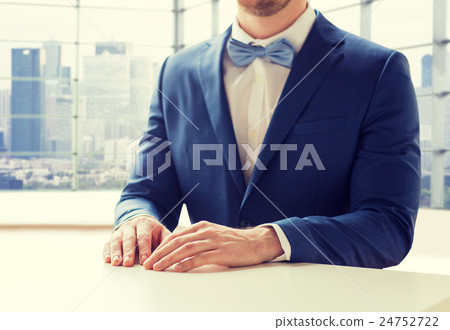 close up of man in suit and bow-tie at table close up of man in suit and bow-tie at table 24752722