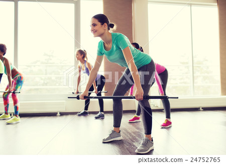 group of people exercising with bars in gym group of people exercising with bars in gym 24752765