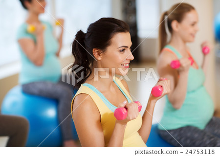 happy pregnant women exercising on fitball in gym 24753118