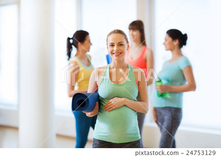 happy pregnant woman with mat in gym 24753129