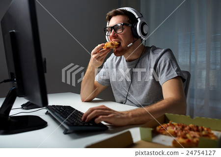 man in headset playing computer video game at home man in headset playing computer video game at home 24754127