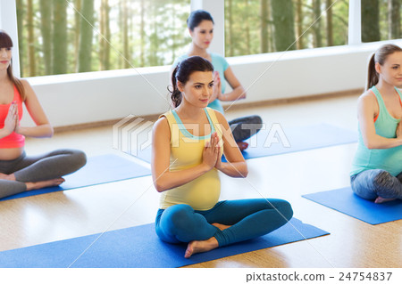 happy pregnant women exercising yoga in gym 24754837