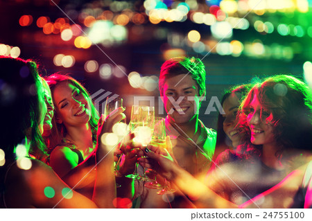 smiling friends with glasses of champagne in club smiling friends with glasses of champagne in club 24755100
