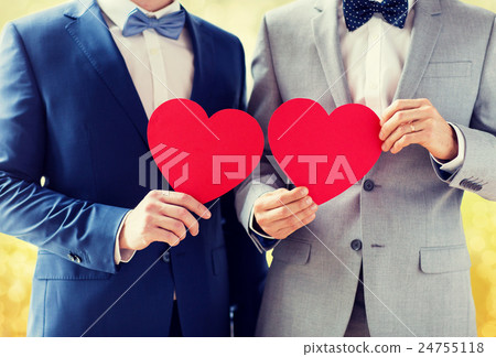 close up of male gay couple holding red hearts 24755118
