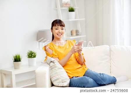 happy asian woman with smartphone at home happy asian woman with smartphone at home 24755608