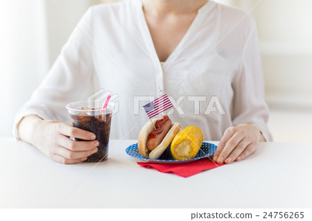 close up of woman eating hot dog with cola 24756265