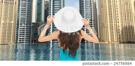 woman in sun hat from back over dubai city pool woman in sun hat from back over dubai city pool 24756984
