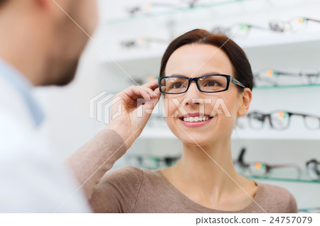 woman choosing glasses at optics store 24757079