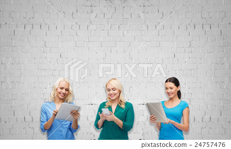 happy women with smartphone and tablet pc computer happy women with smartphone and tablet pc computer 24757476