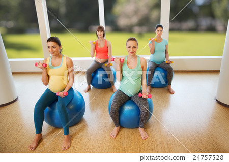 happy pregnant women exercising on fitball in gym 24757528