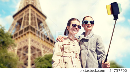 girls with smartphone selfie stick at eiffel tower 24757700