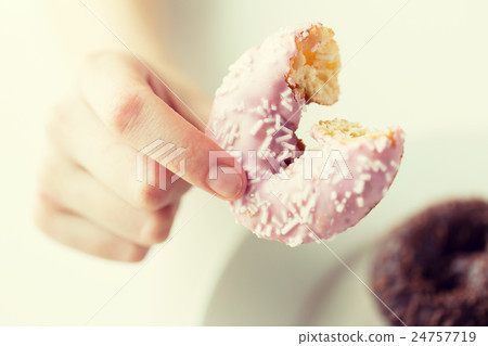 close up of hand holding bitten glazed donut close up of hand holding bitten glazed donut 24757719