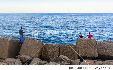 amateur fishermen who fish from the dock in a port amateur fishermen who fish from the dock in a port 24765383