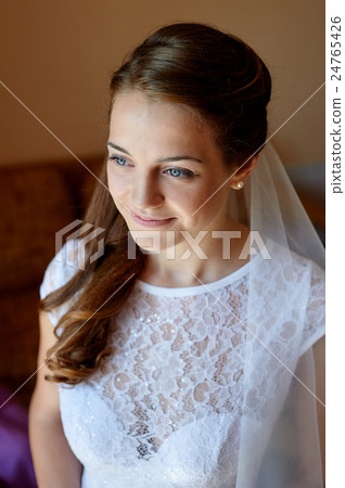 Beautiful bride standing near the window and 24765426