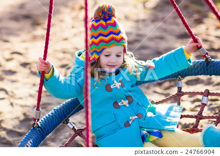Child on playground swing 24766904