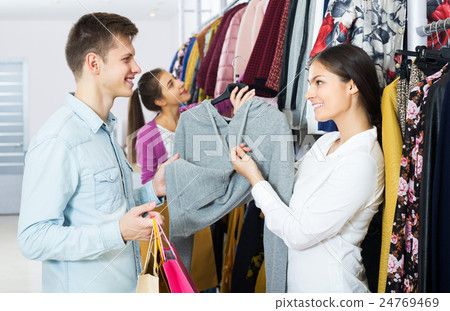 Spouses carrying bags in boutique 24769469